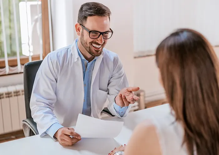 Médico sorrindo durante a consulta com uma paciente